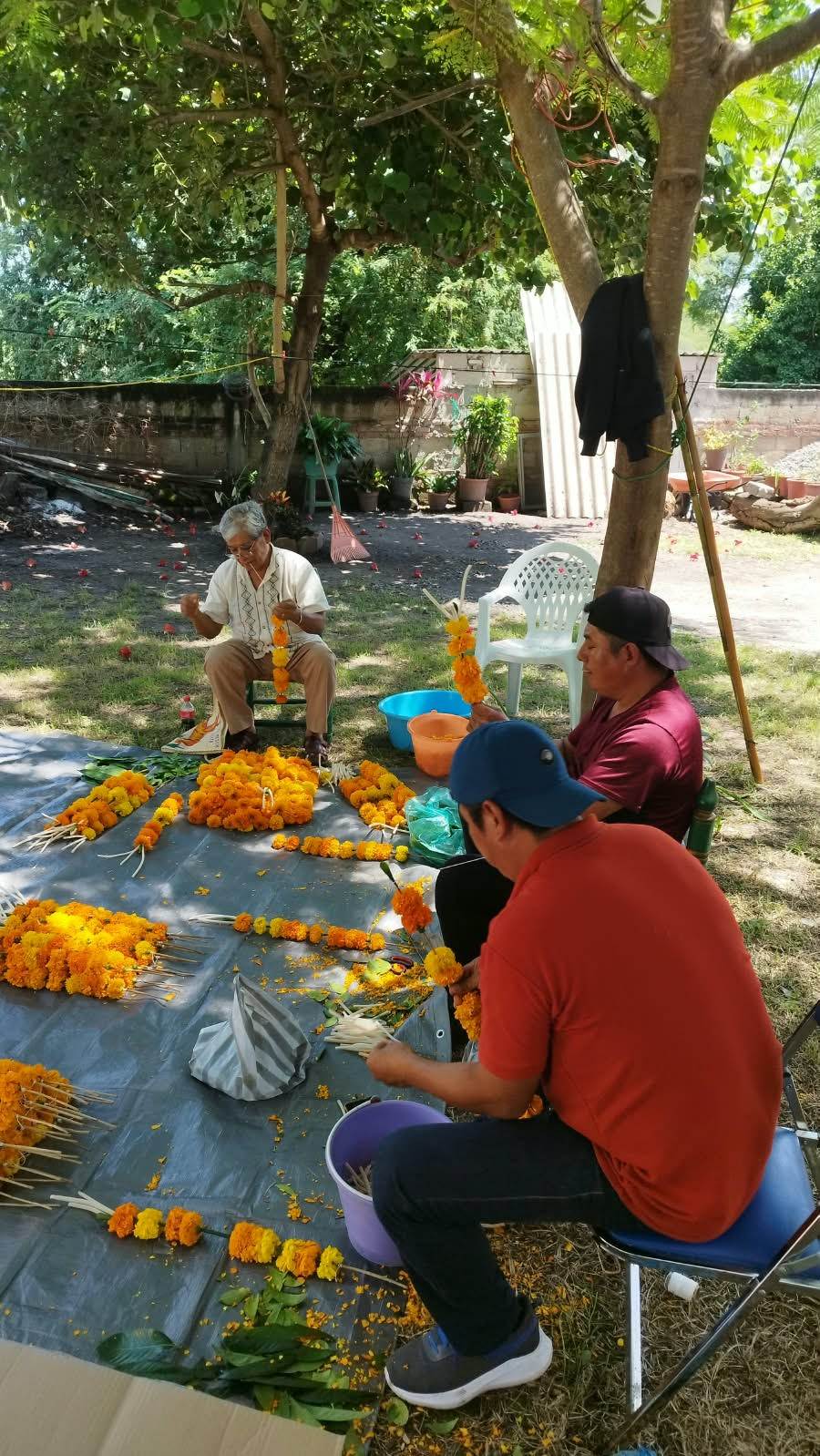 Personas preparando arreglos con flores de cempasúchil